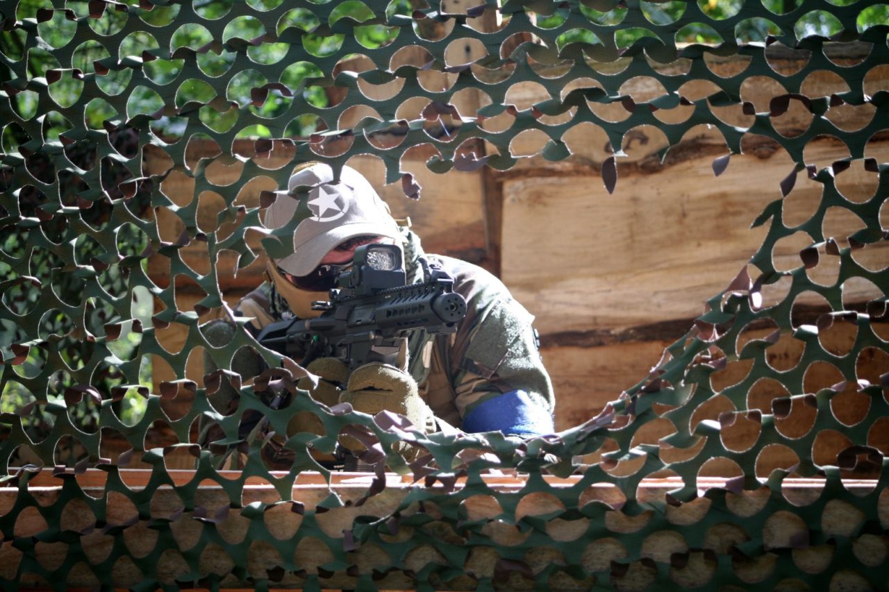 Airsoft speler kijkt door een camo net op het hulsbeek in oldenzaal